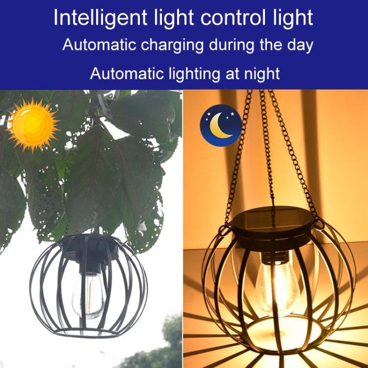 Small solar lantern light with black metal cage and hanging chain, daytime