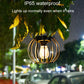 Lit small black metal solar lantern light under rain, hanging chain visible