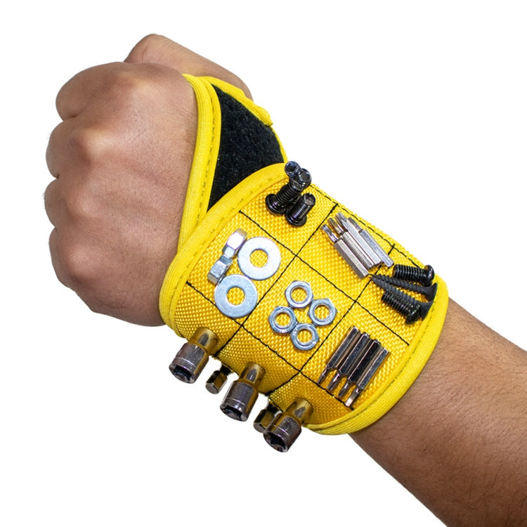 Yellow magnetic thumb wrap tool storage strap on hand with tool bits attached