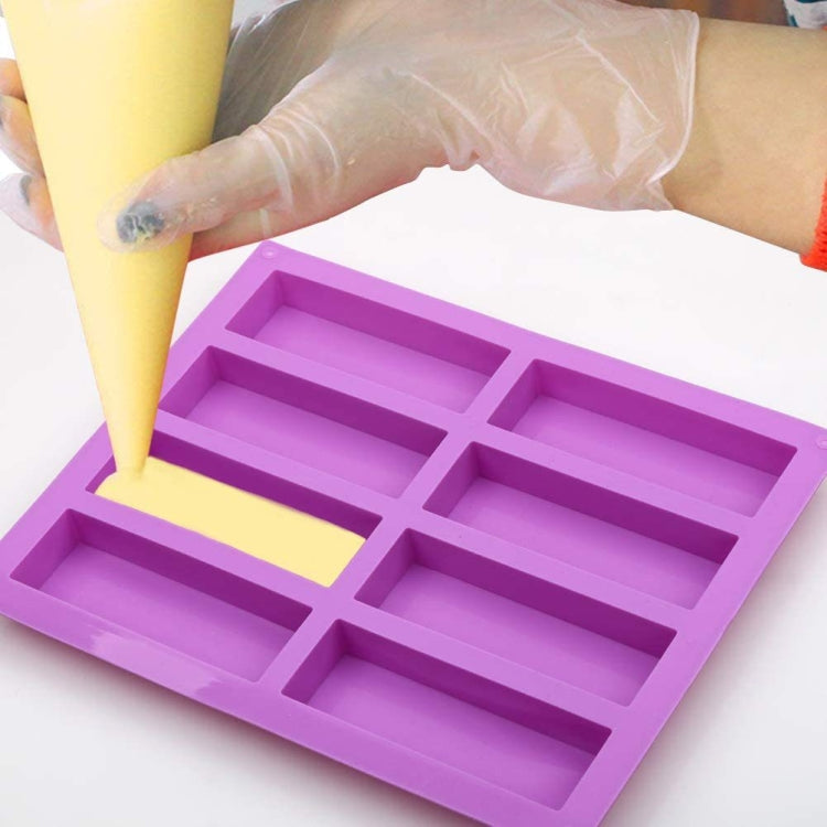 Purple silicone soap mold with 8 channels, filled with soap batter by piping