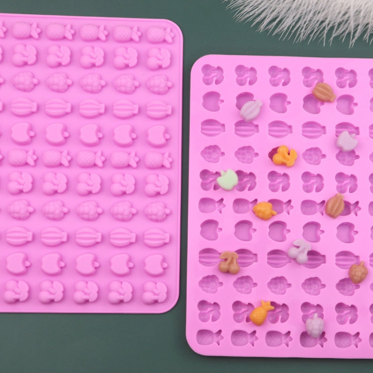 Two-piece pink silicone candy mold tray with fruit-shaped cavities and sample pieces