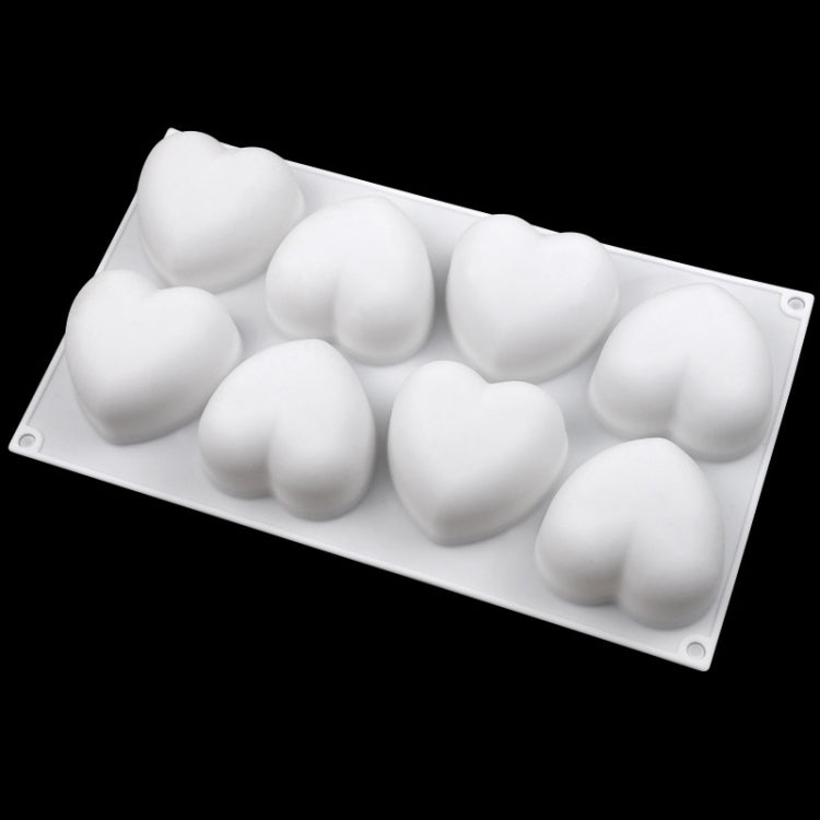 Silicone heart mold with eight white heart-shaped pieces in cavities