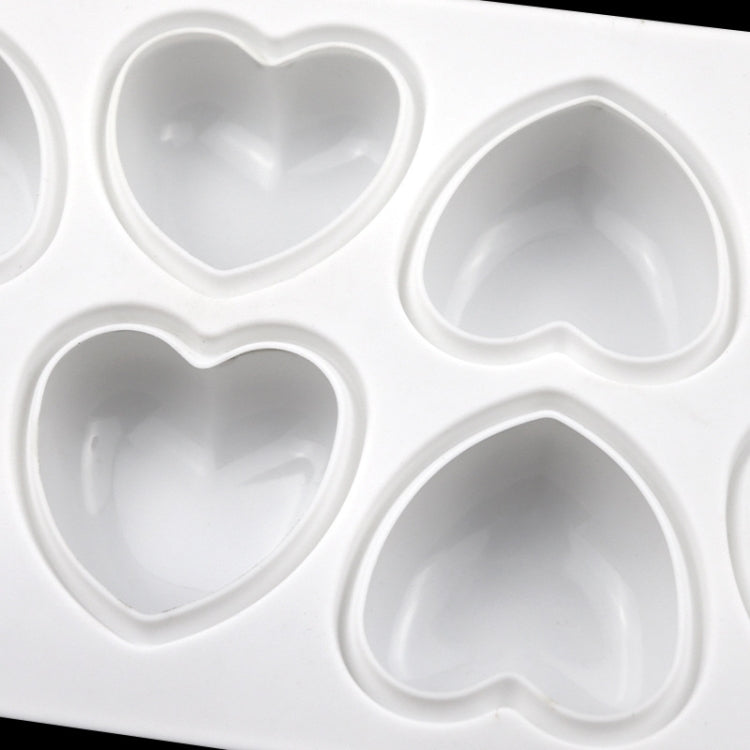 Close-up of silicone heart cavities on white rectangular mold tray