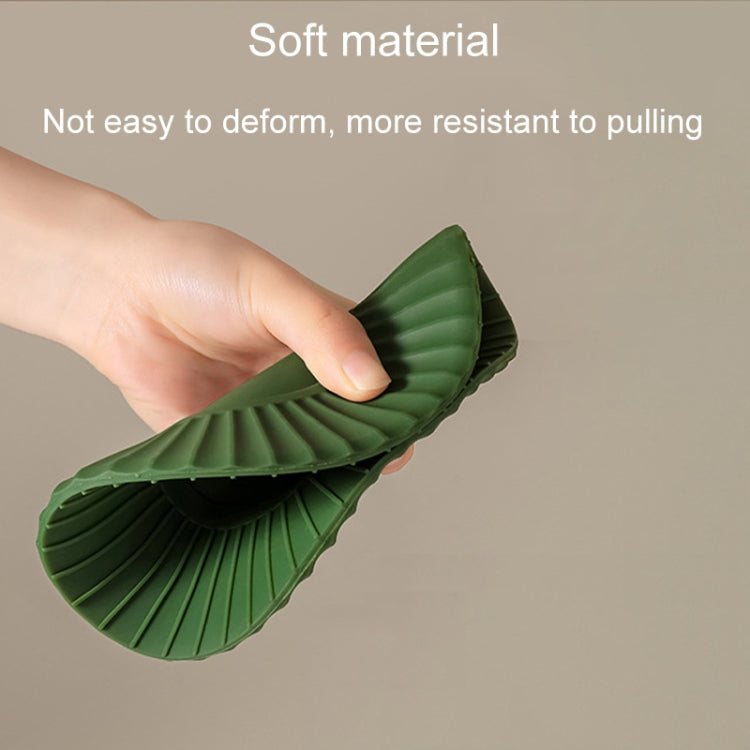 Green silicone heat insulation mat shown flexing, ridged outer edge and center.
