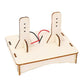 DIY DC motor science kit board with copper coil ring and two wire leads on terminals