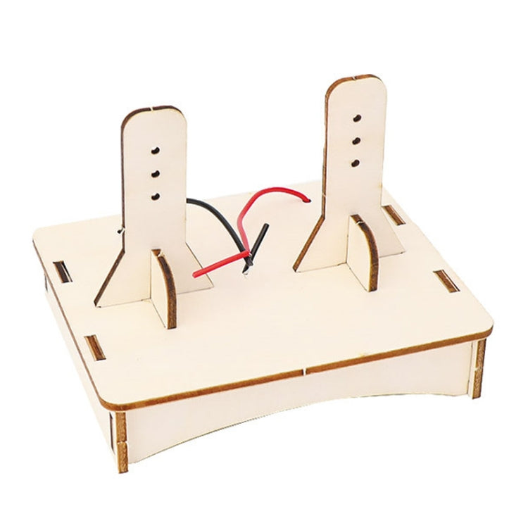 DIY DC motor science kit board with copper coil ring and two wire leads on terminals
