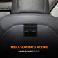 Tesla Model 3/Y close-up of two black plastic rear seat headrest hooks on seat back.