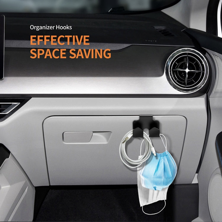 Black storage box hooks holding hanging face masks on a car console panel
