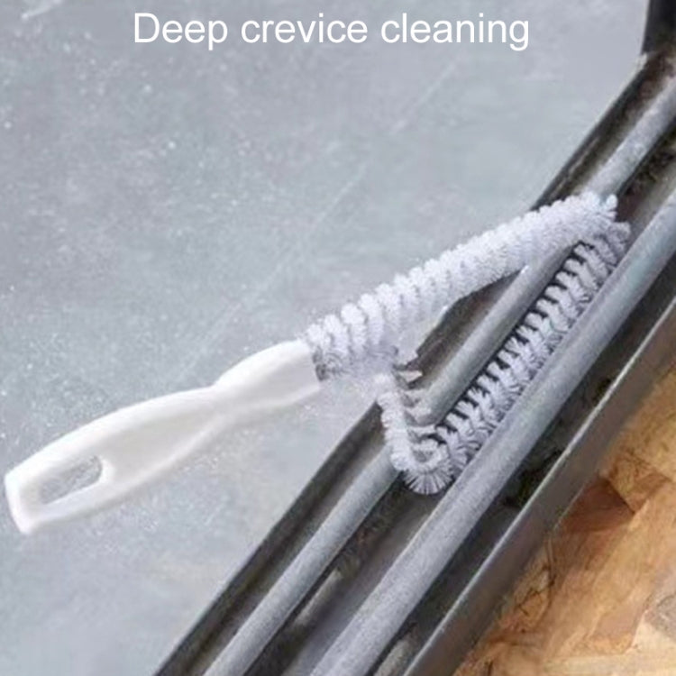Crevice brush head scrubbing between window track gaps with dense white bristles