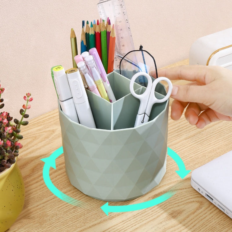 Light green rotating desk organizer bucket holding pens and scissors, hand in frame