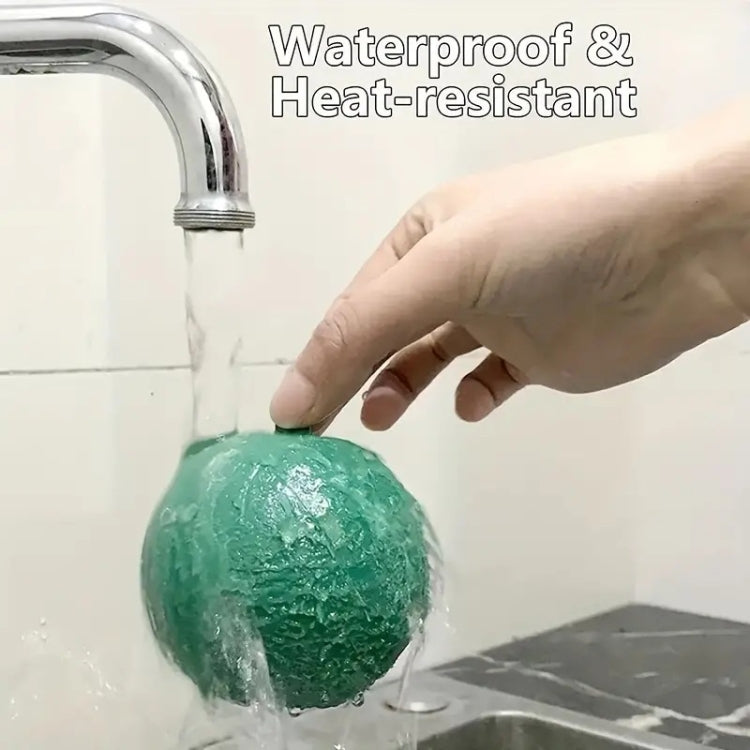 Green sticky trap ball with hanging loop, being rinsed under running water