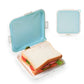 Blue silicone sandwich bread storage box with open lid and sandwich inside