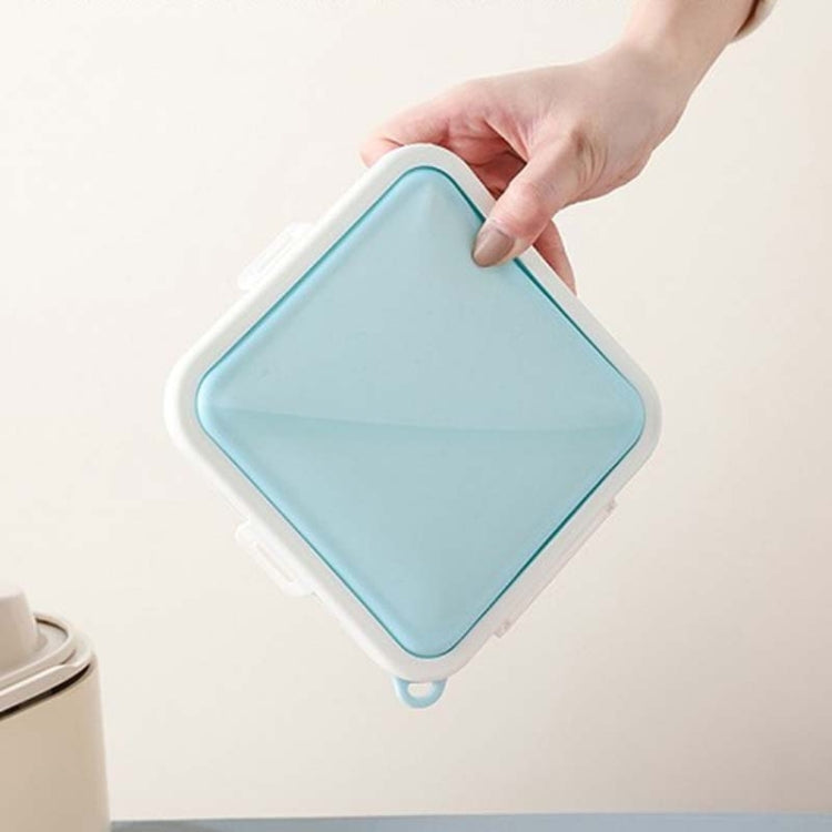 Blue silicone sandwich storage box held by hand with lid closed