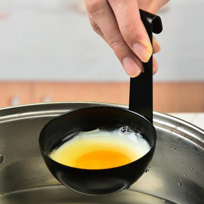 Black egg poaching mould with hanging handle, holding a poached egg in a pan.