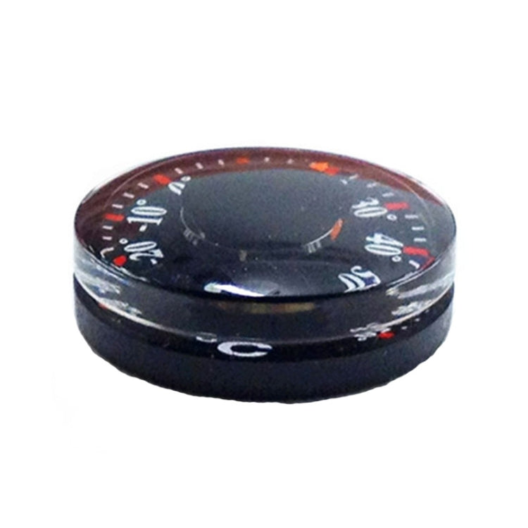 Round black plastic thermometer with domed top and clear cover showing °C markings