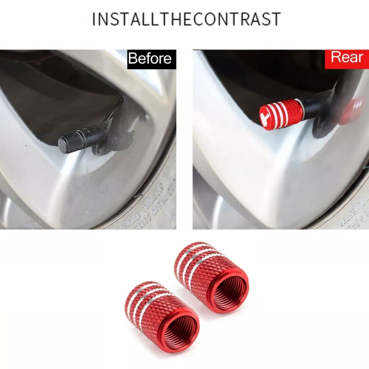 Red tire valve caps installed on a wheel rim, shown with close-up view