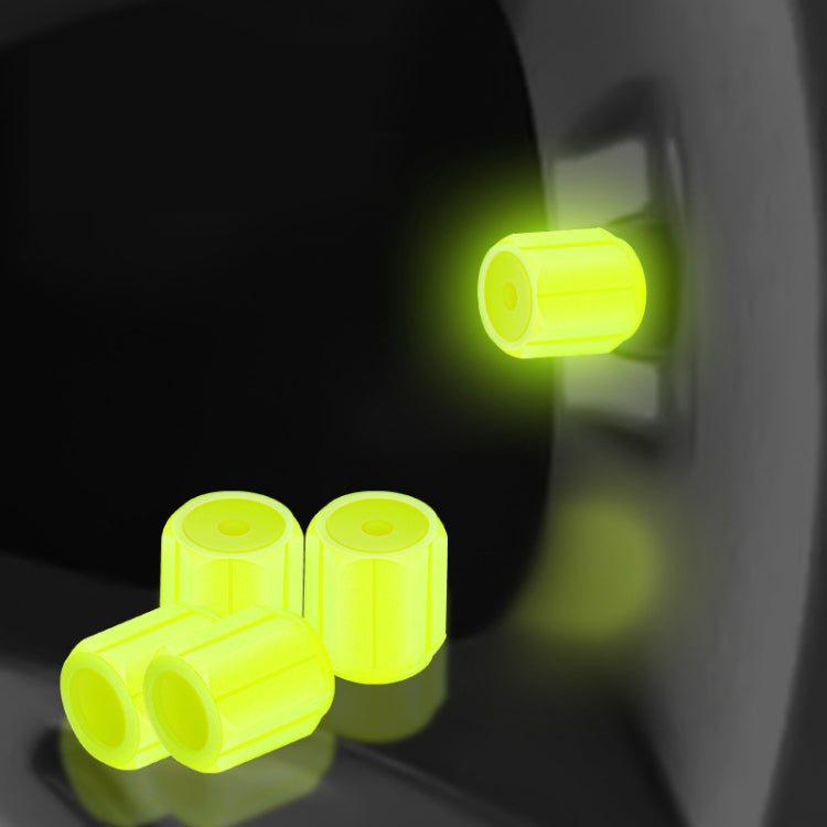 Yellow luminous car tire valve caps set, glowing at the wheel valve stem