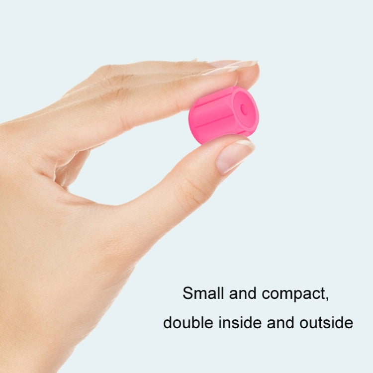 Pink luminous tire valve cap held in hand, compact size