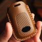Brown leather smart remote key case close-up with textured panel and oval cutout