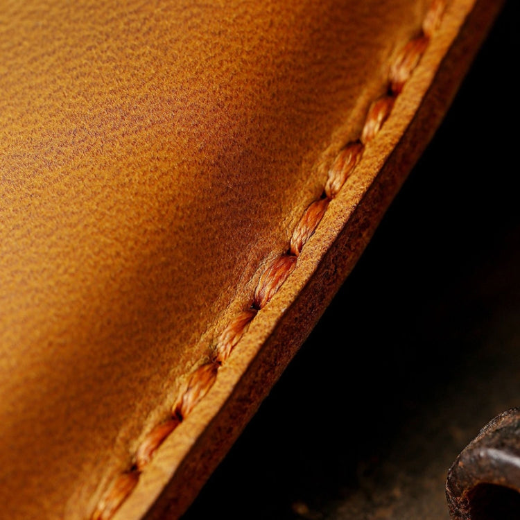 Close-up of tan leather key fob cover seam and burnished edge stitching