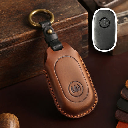 Brown leather remote key protective case with key ring loop and button icon panel.