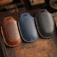 Leather remote key protective cases in brown, blue, and black with textured button covers.