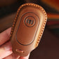 Brown leather remote key protective case with speaker button icon and key lanyard slot.