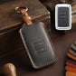 Dark leather car key case with stitched edges and key ring loop, remote view