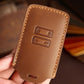Tan leather car key case back with embossed button icons and key ring loop