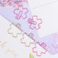 Assorted sakura-shaped metal paper clips in pink, gold, and rose gold on cards