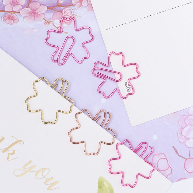 Assorted sakura-shaped metal paper clips in pink, gold, and rose gold on cards