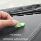 Hand placing a small green luminous up-arrow sticker on car interior surface