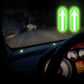 Glowing green up-arrow car stickers on dashboard and console area at night
