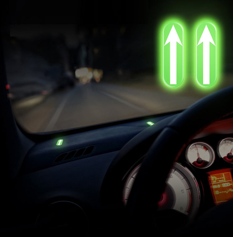 Glowing green up-arrow car stickers on dashboard and console area at night