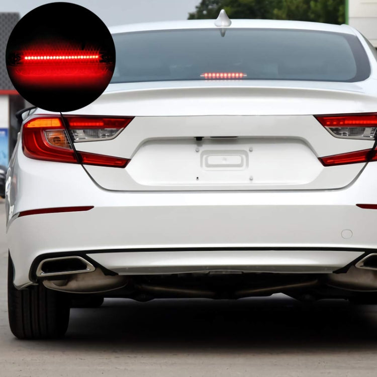 Car rear showing lit red high-mounted brake light bar