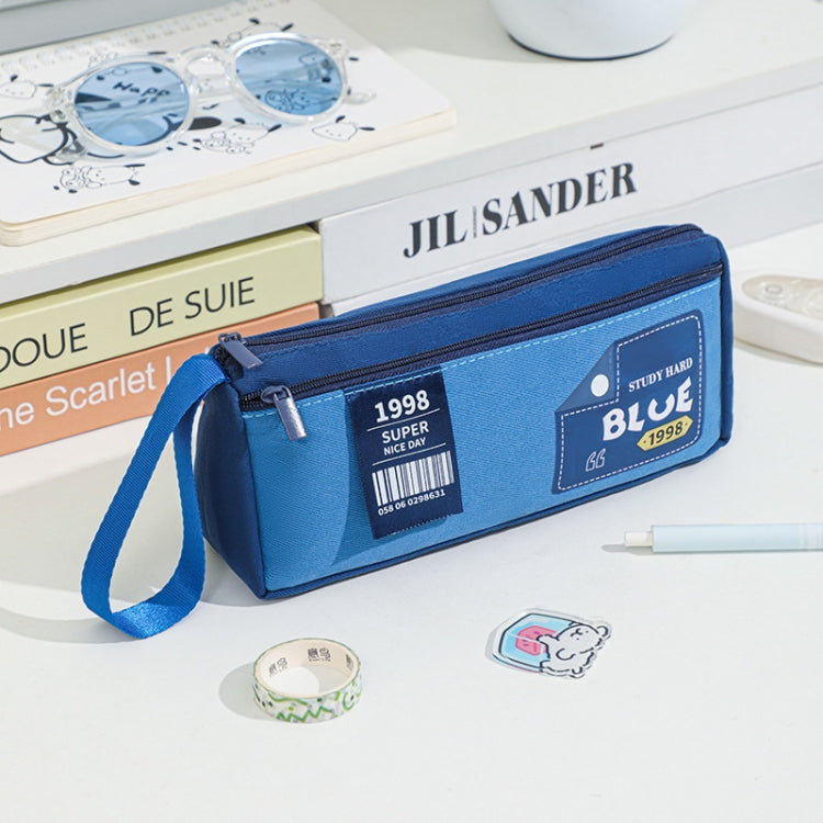 Navy blue double-layer pencil case with wrist strap and front badge patch.