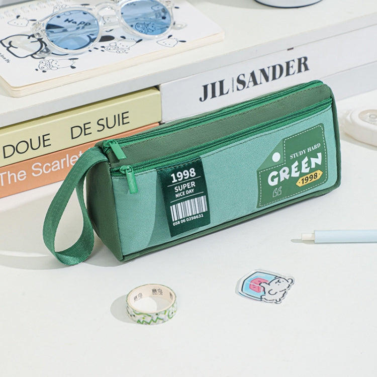 Green double-layer pencil case with wrist strap and front badge patch.