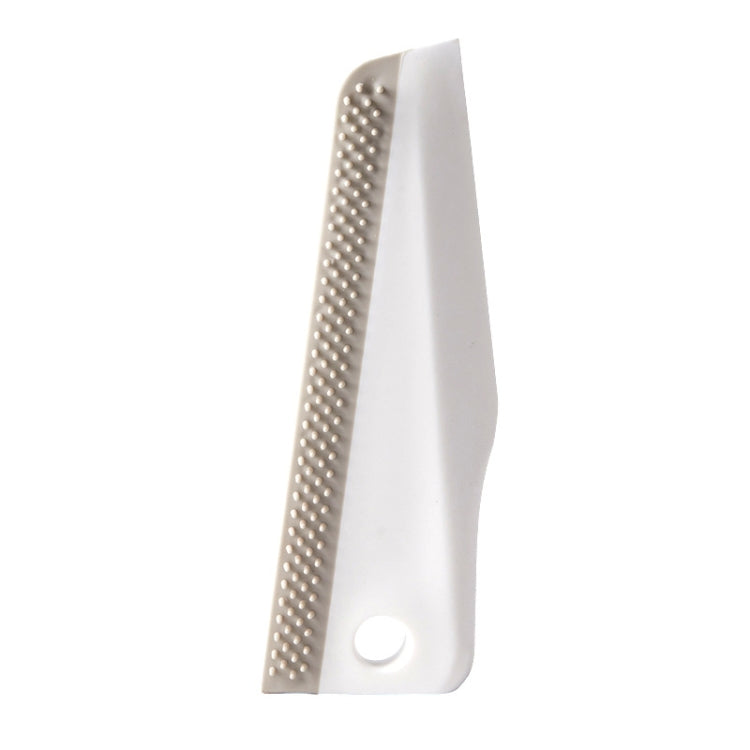 Manual cleaning scraper with perforated brush strip on white plastic handle