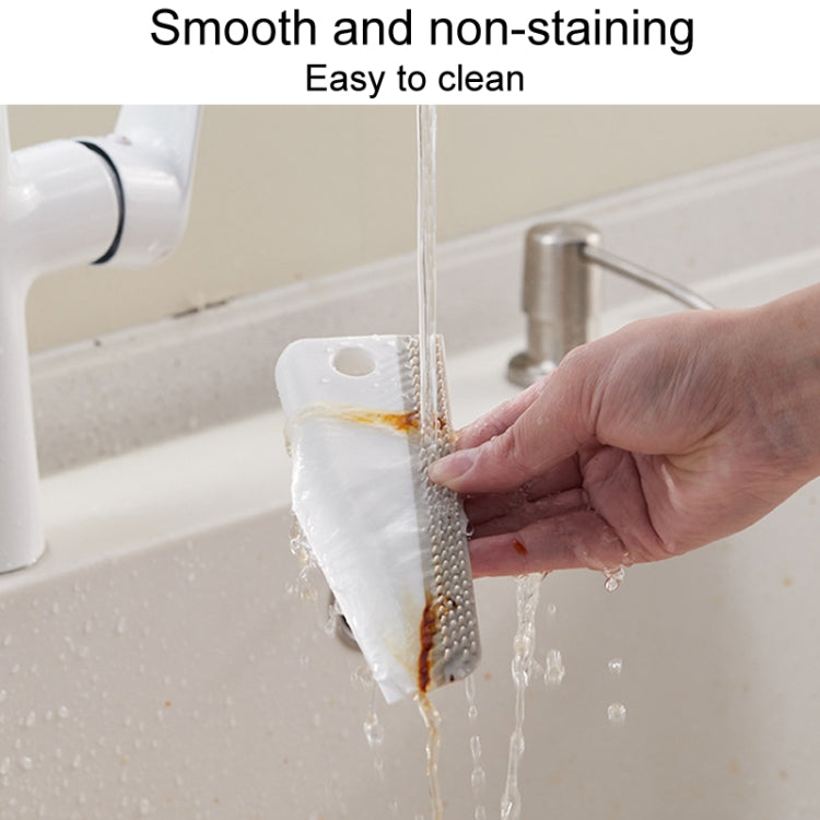 Manual cleaning scraper brushing away grime on a sink edge with stream of water