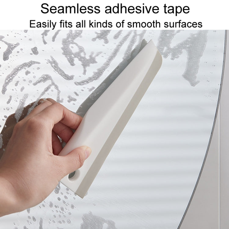 Manual cleaning scraper with integrated adhesive tape for mounting on smooth surfaces