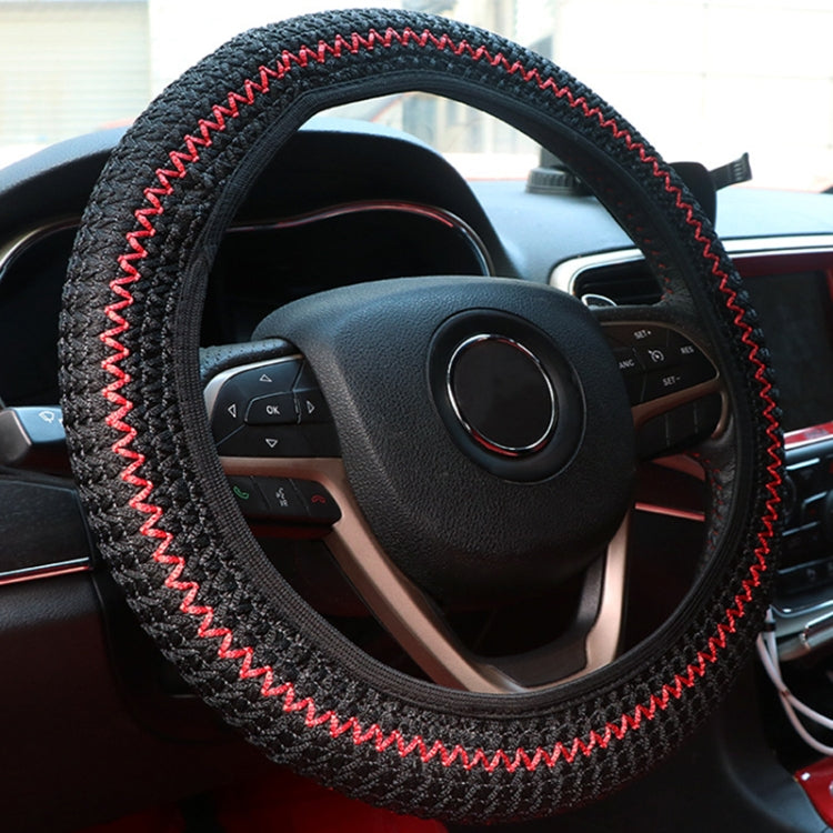 Black steering wheel cover with red zigzag stitching, textured fabric ring