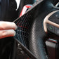 Steering wheel cover edge with red stitching on textured black fabric