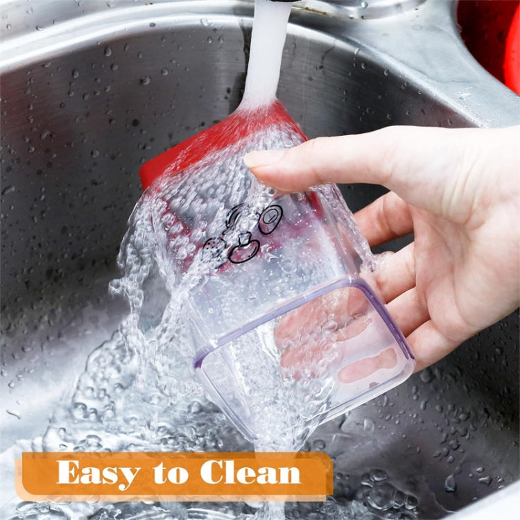 Clear slicer container with red push plate rinsed under running water