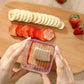 Hand holding clear slicer with red frame over sliced fruit on a wooden board