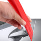 Red plastic dent repair support clip touching car door handle area, held by hand