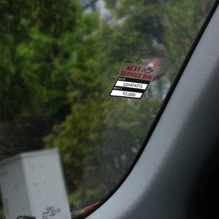 Window sticker on car windshield reading “NEXT SERVICE DUE” with date and miles