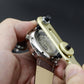 Watch repair tool being used on a watch case and brown leather strap