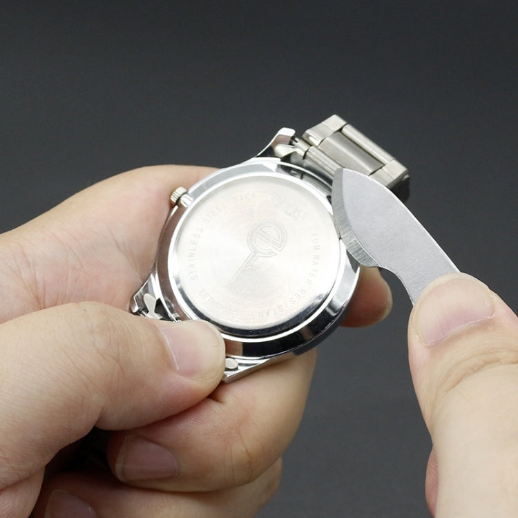 Watch repair tools: hands hold a watch while prying the case back
