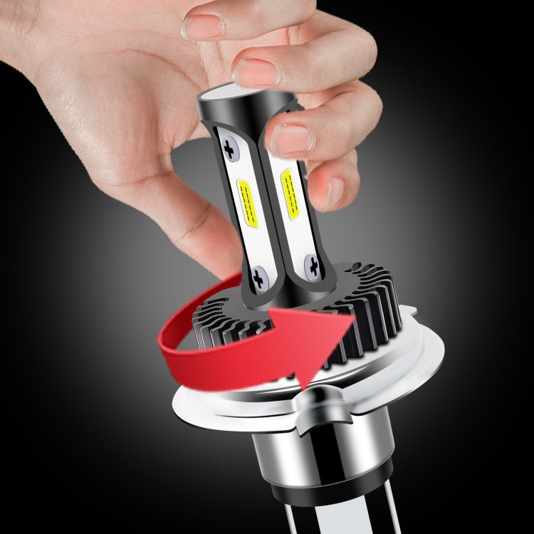 High-brightness LED car headlight bulb being installed by hand with black fins and silver base