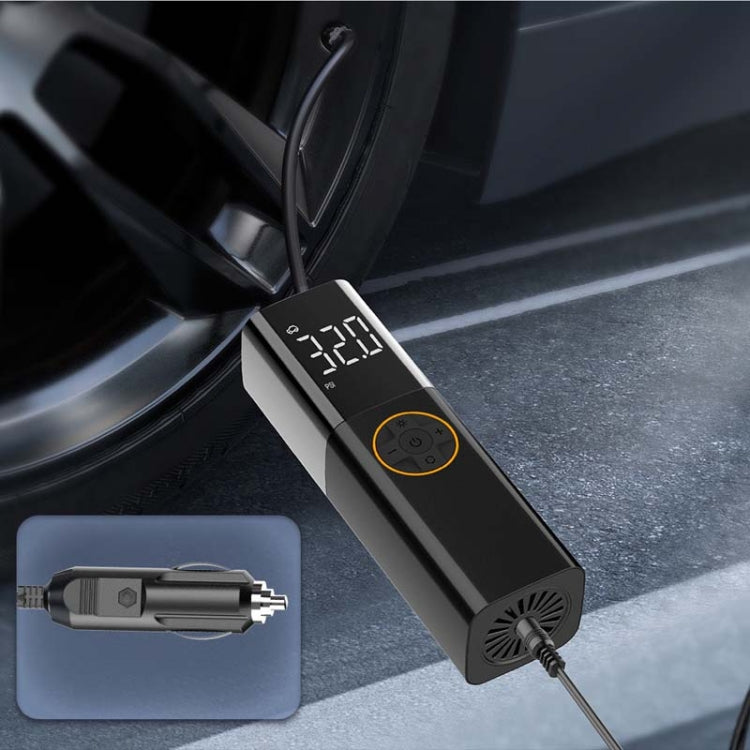 Portable digital air pump with metal nozzle adapter on car interior floor